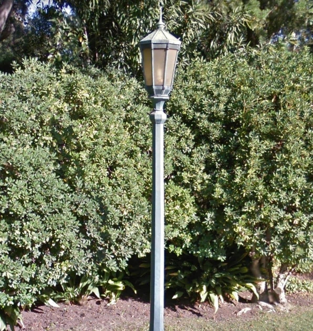 A historic ornamental street light on a residential street.