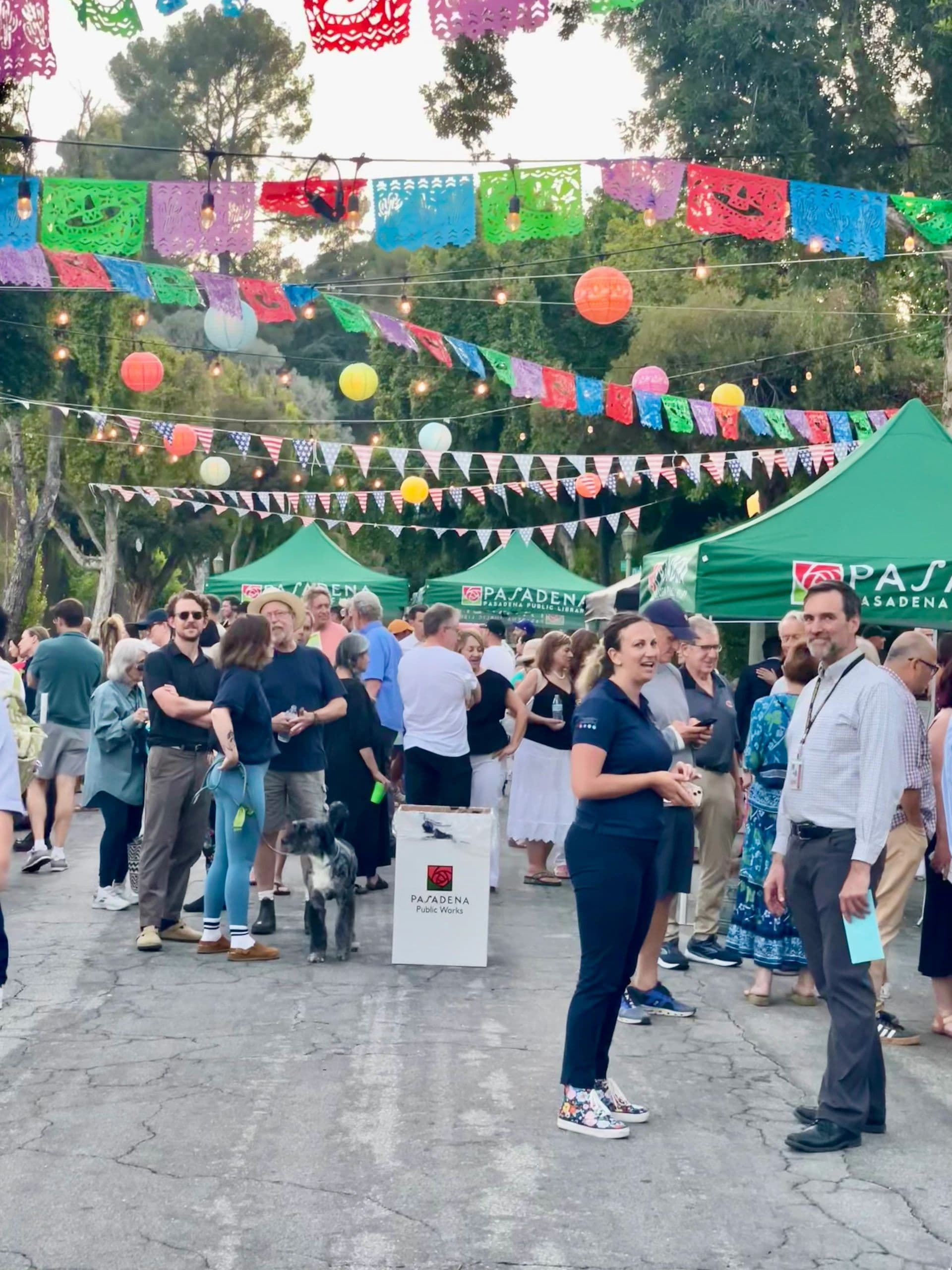 Outdoor festival with colorful decorations and people socializing.